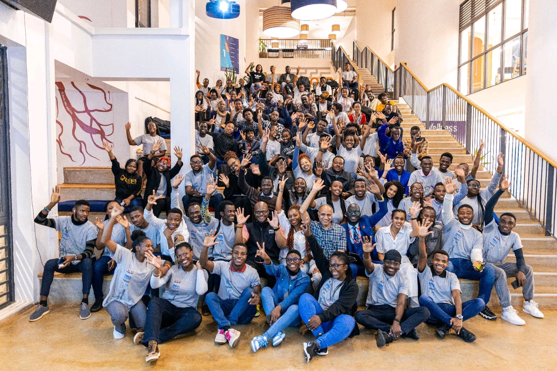 JointHub Africa leaders and partners gathered on a staircase, smiling and waving